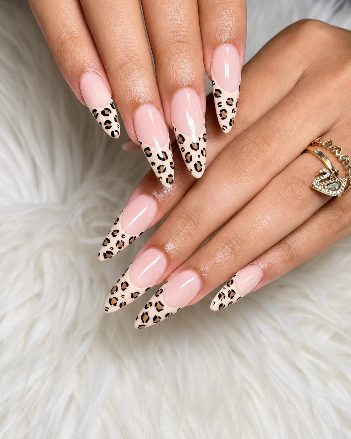 Long almond nails in sheer nude with hand-painted leopard print accent nails