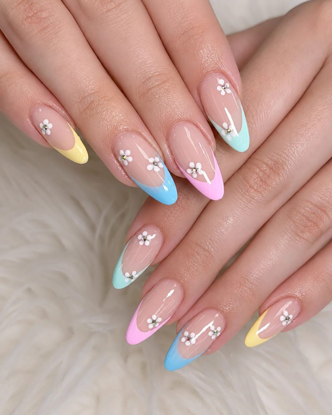 Almond nails with pastel French tips, photographed close up to show the seal at the cuticle