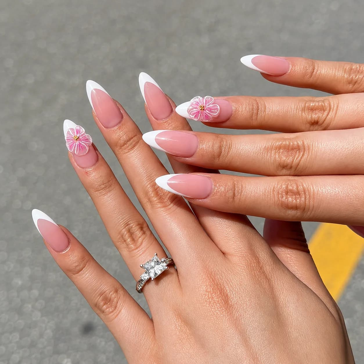 Pink and white French manicure on almond nails with a sculpted 3D floral accent