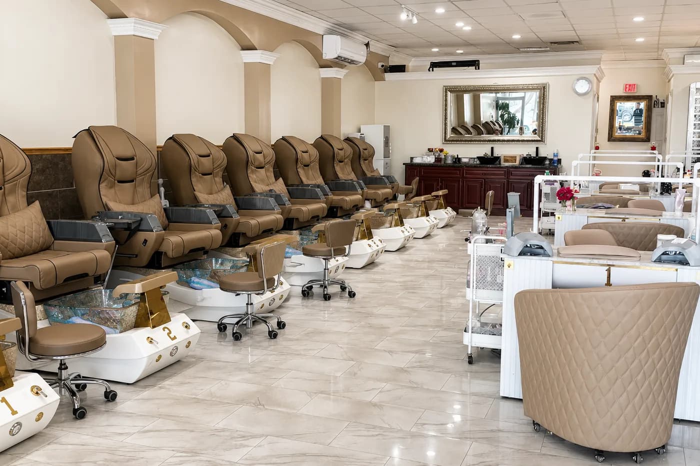 Row of cushioned pedicure spa chairs with individual footbaths inside Utopia Nails Spa